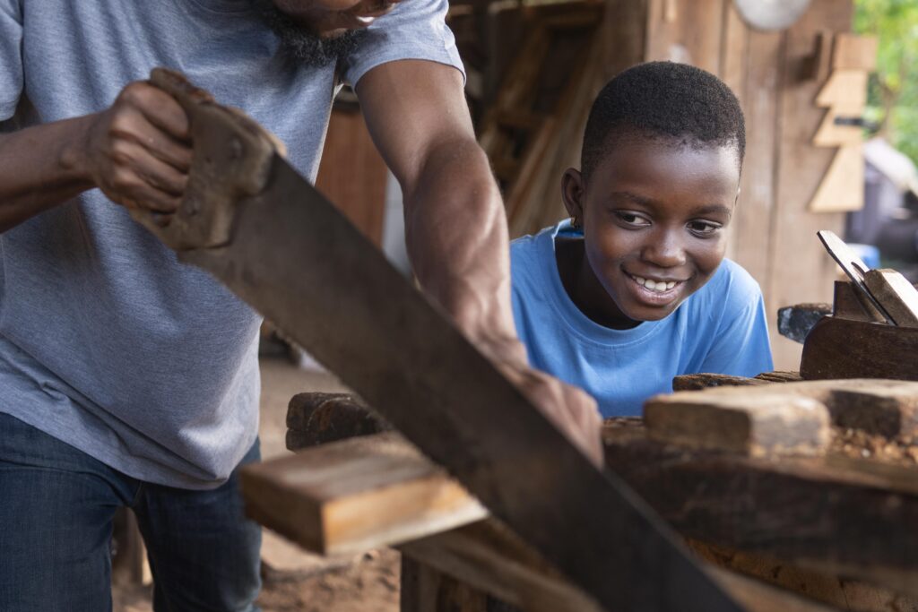 Young man using a hand saw during skills training
